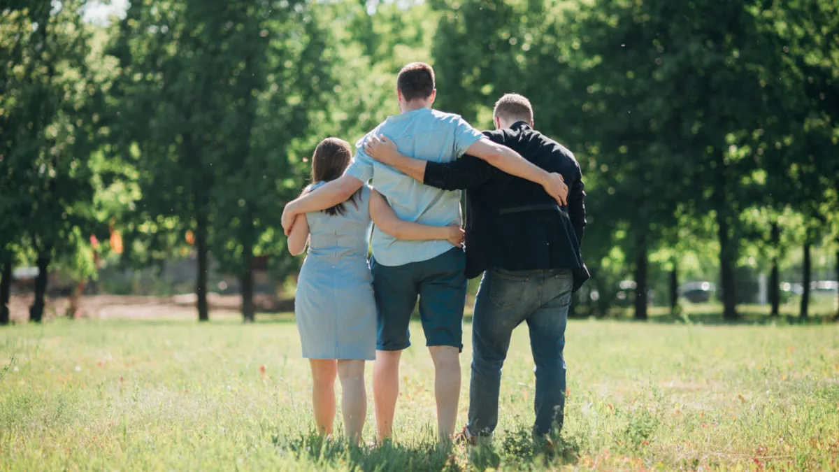 Família caminhando abraçada em um parque