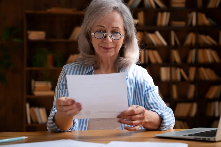 Senhora lendo um documento em casa